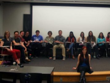 Kristen Batko sits center stage surrounded by a partial cast of readers for PSYCHOS, her original one-hour television drama.